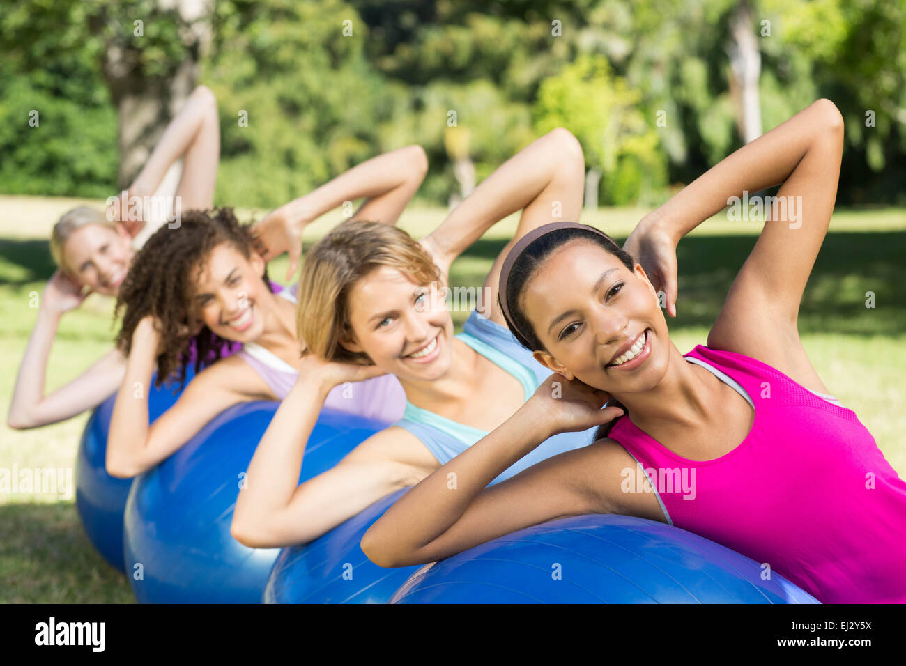 Fitness group using exercise balls in park Stock Photo Alamy