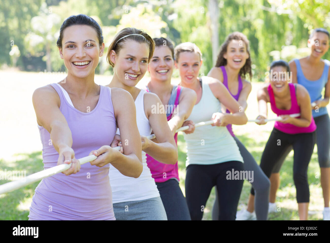 Fitness group playing tug of war Stock Photo