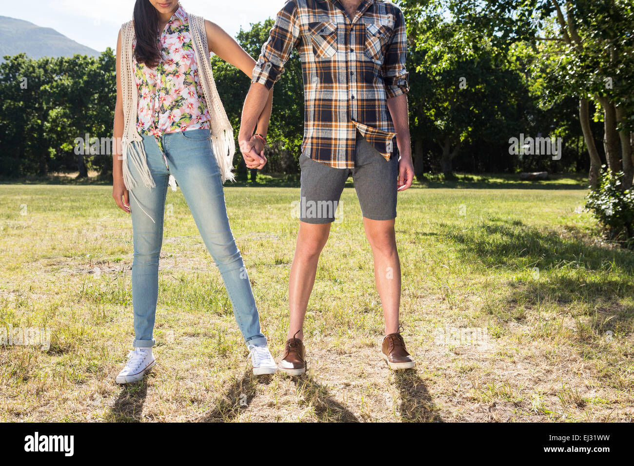 Couple holding hands in park Stock Photo - Alamy