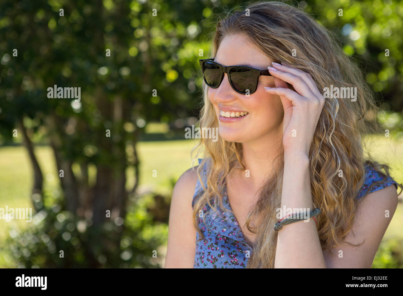 Pretty blonde smiling in the park Stock Photo - Alamy