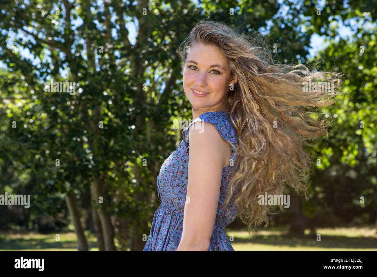 Pretty blonde smiling in the park Stock Photo - Alamy