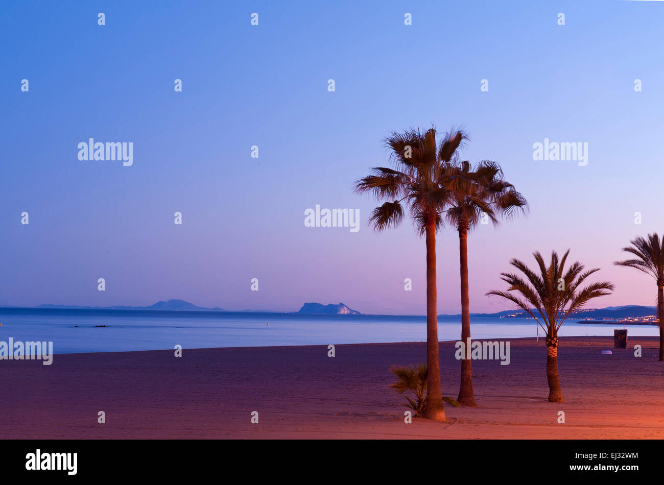 Estepona beach, La Rada, looking out to Gibraltar and Africa on The horizon. Costa del Sol, Malaga Province Spain. Three palms Stock Photo