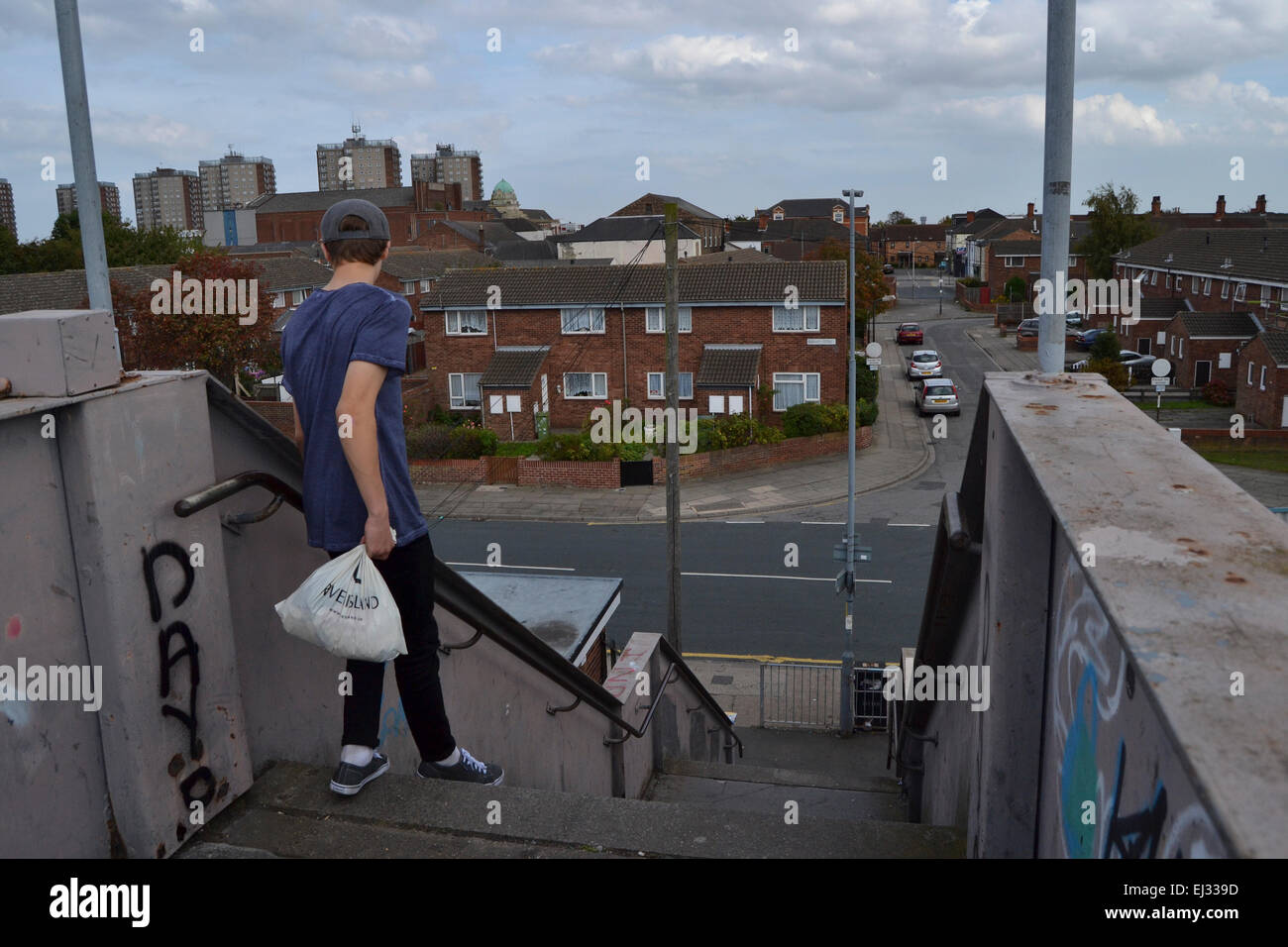 Teenage boy walking down stairs in great Grimsby lincolnshire england Stock Photo