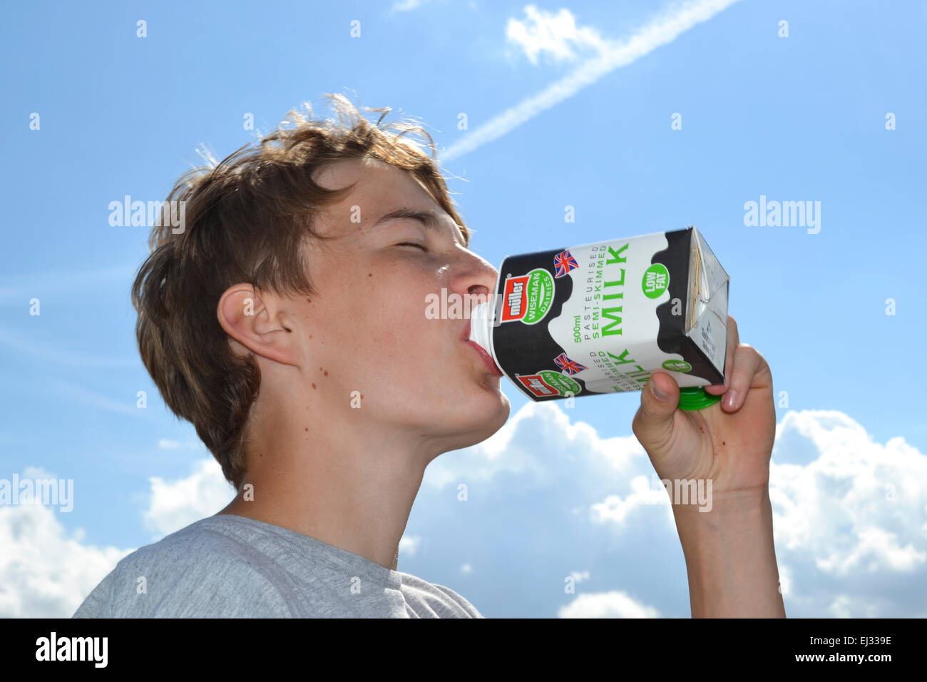 young boy drinking from a milk carton in the summer Stock Photo