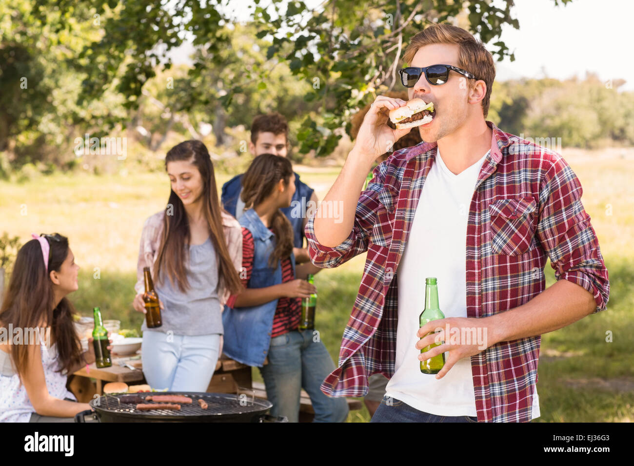 Happy friends in the park having barbecue Stock Photo - Alamy