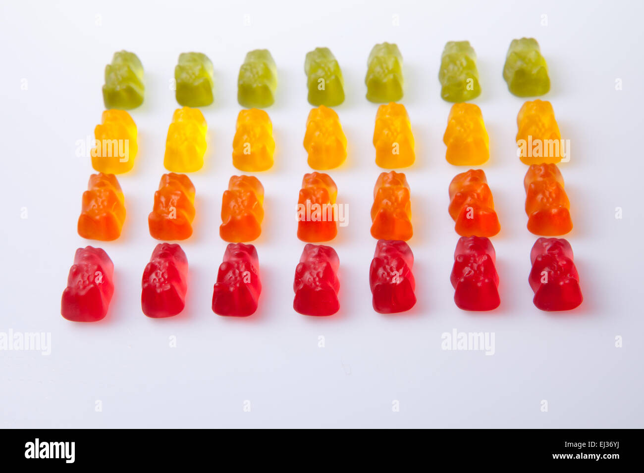 Rows of colorful gummy bears isolated over white background Stock Photo