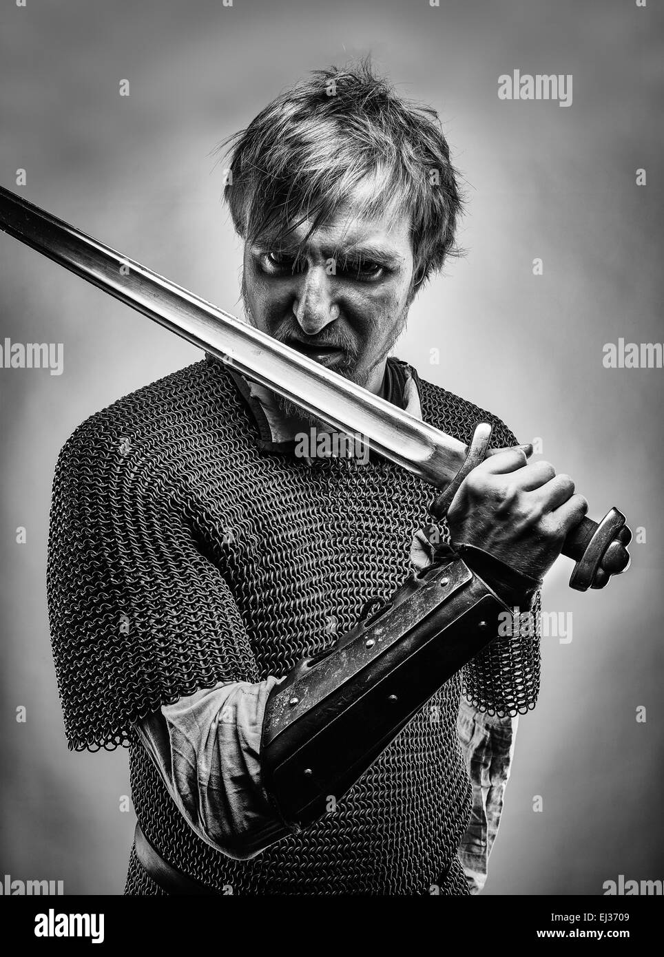 Angry medieval knight armor with a sword, black and white image Stock Photo