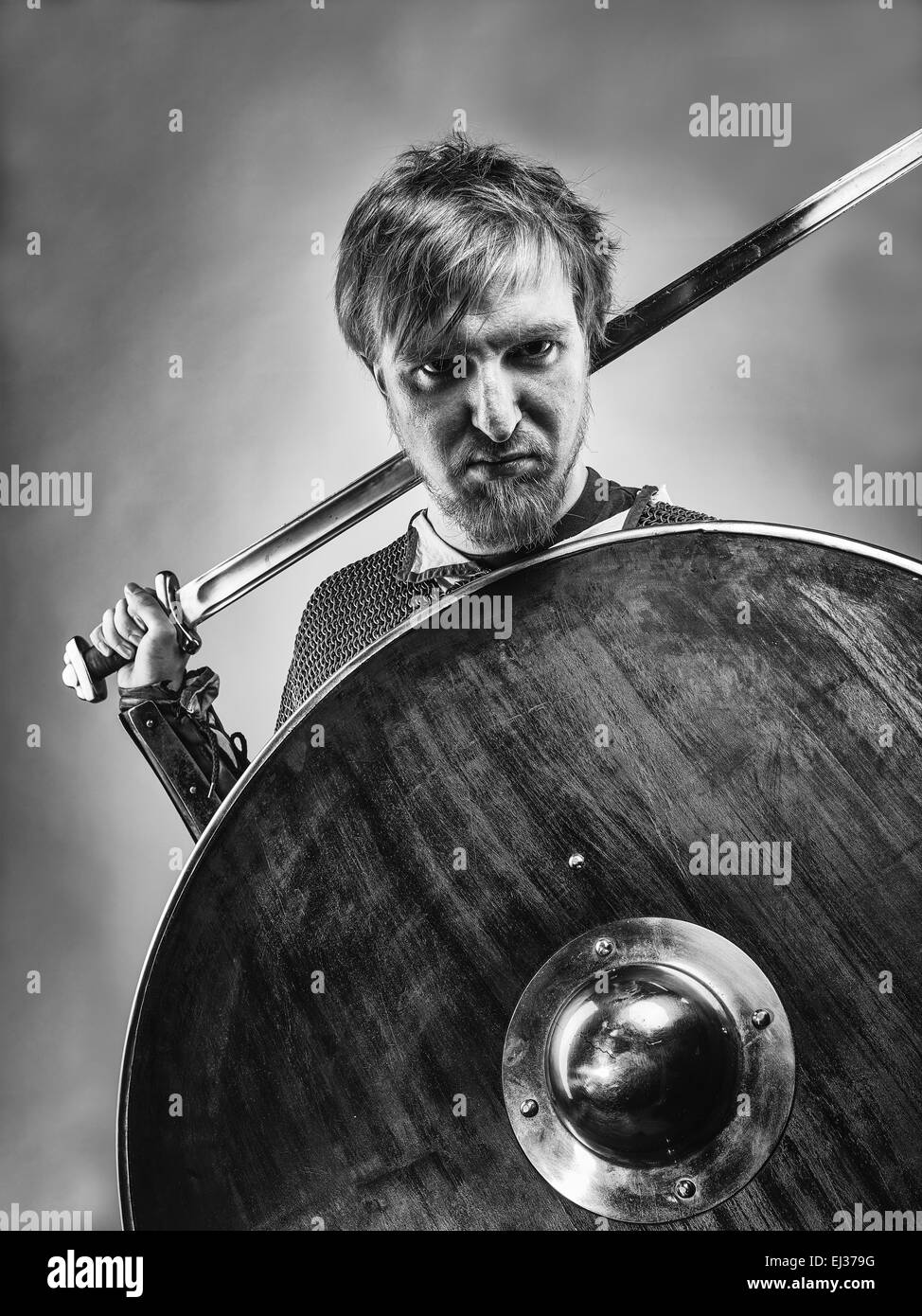 Angry medieval knight armor with a sword and shield, black and white image Stock Photo