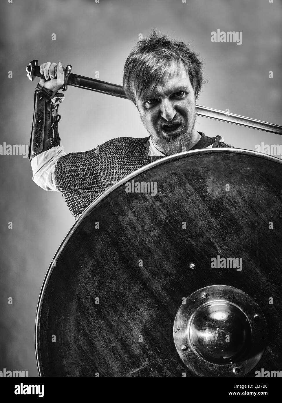 Angry medieval knight armor with a sword and shield, black and white image Stock Photo