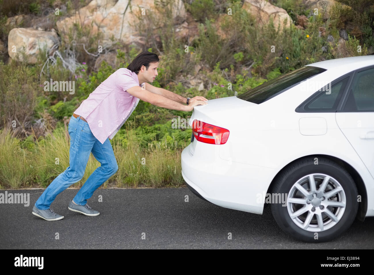 Man pushing car after a car breakdown Stock Photo