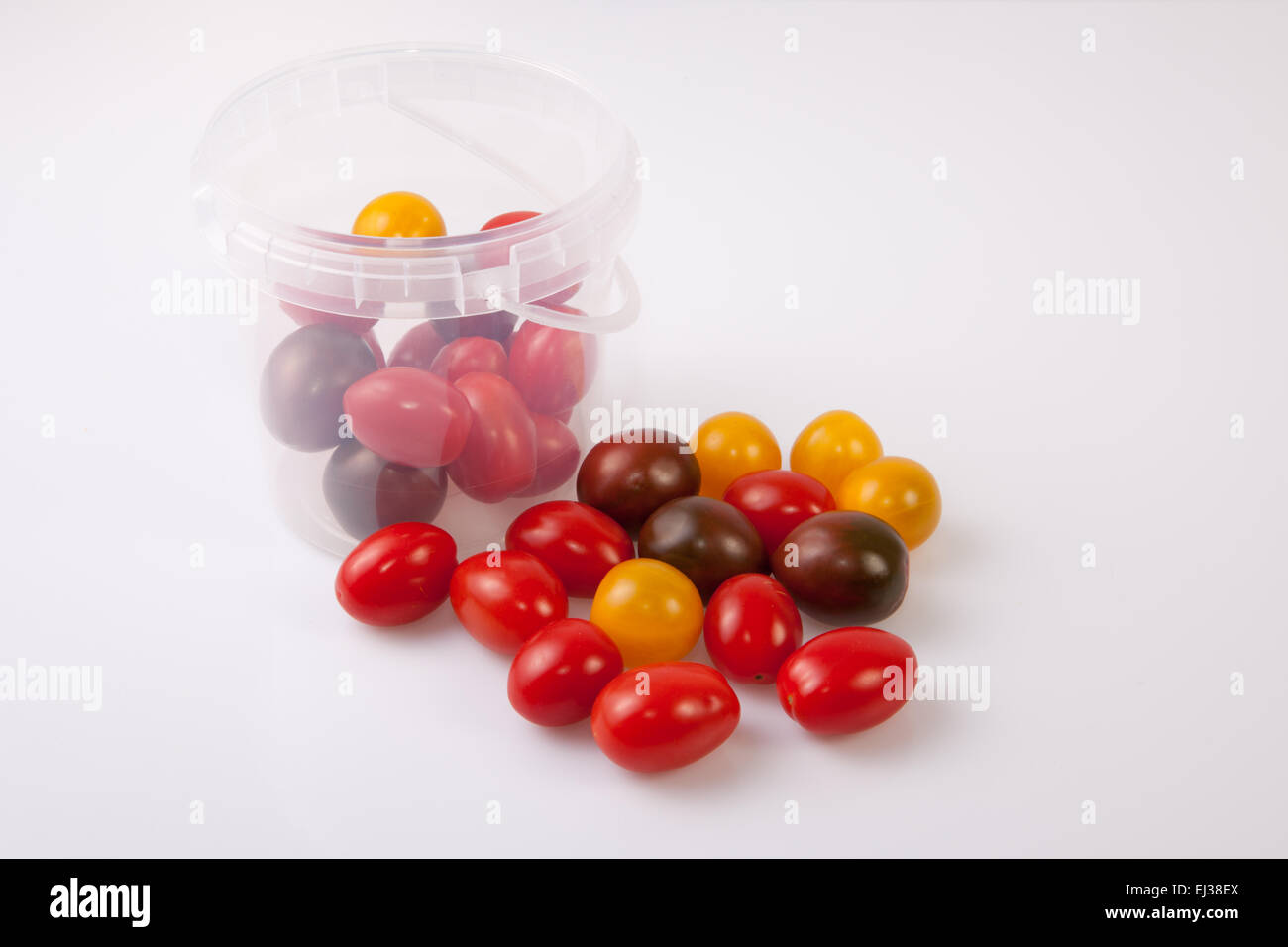 Bucket and colorful cherry tomatoes. Isolated over white background