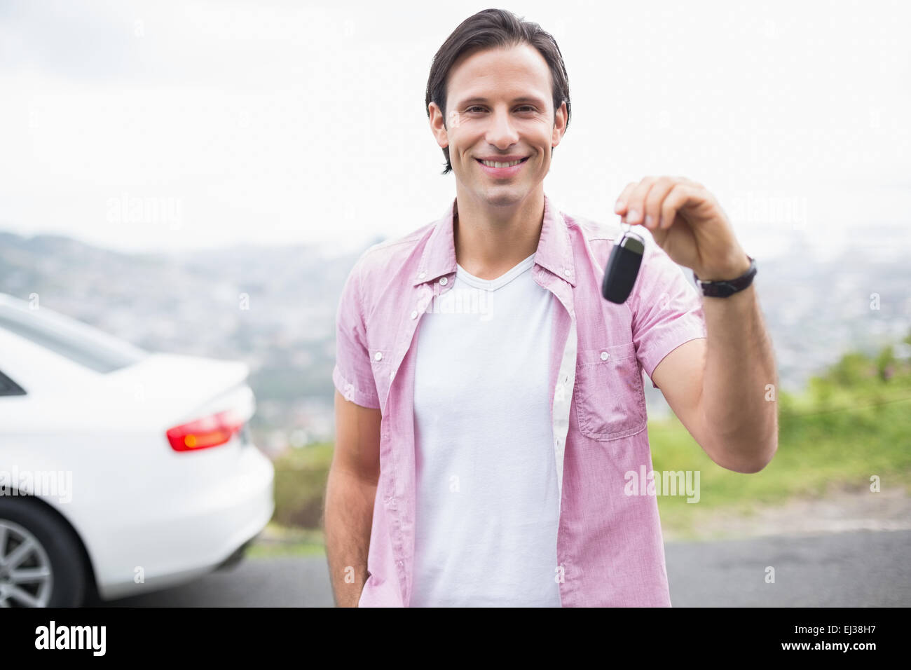Man smiling and showing key Stock Photo - Alamy