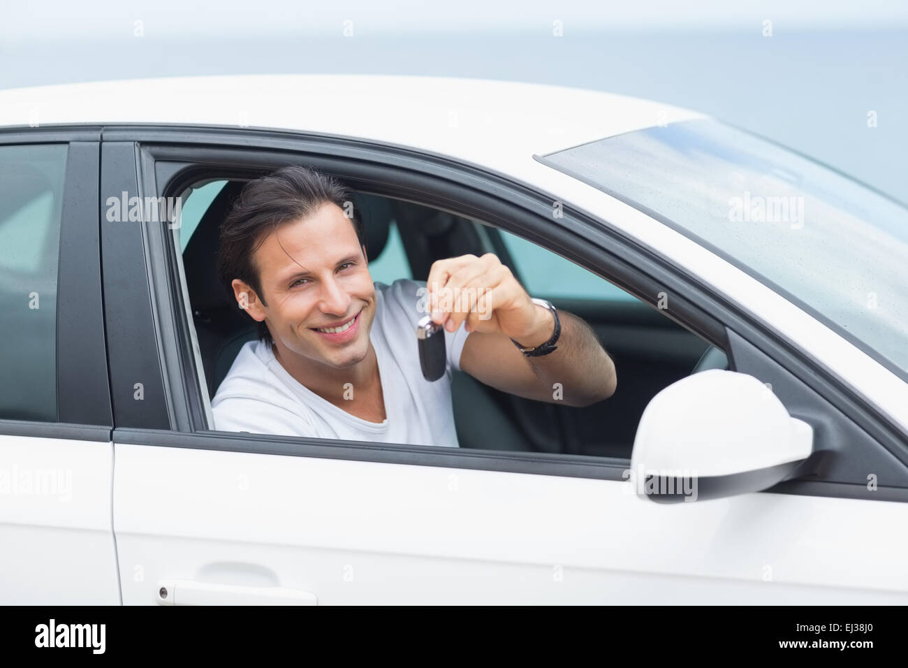 Man smiling and showing key Stock Photo - Alamy