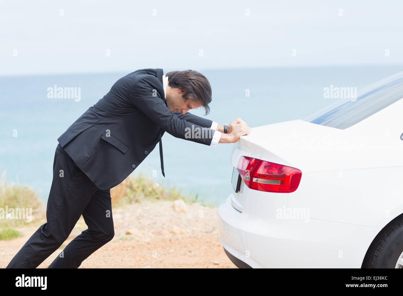Businessman pushing his car Stock Photo