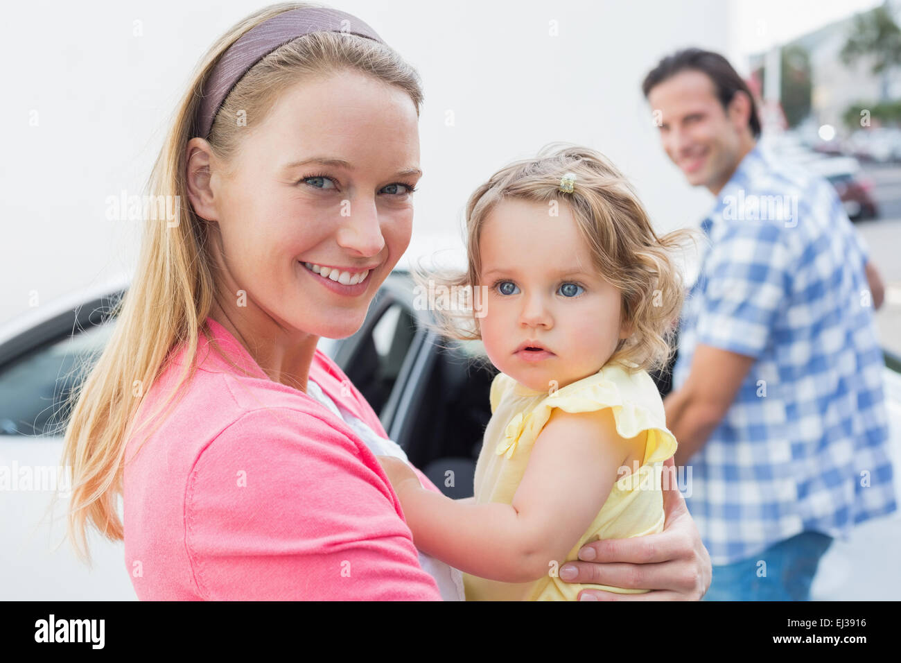 Parents carrying baby and her car seat Stock Photo