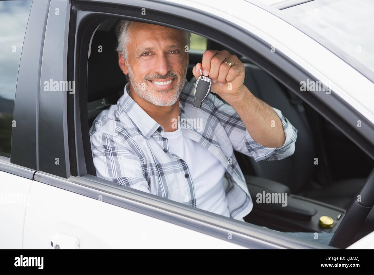 Man smiling and holding key Stock Photo - Alamy