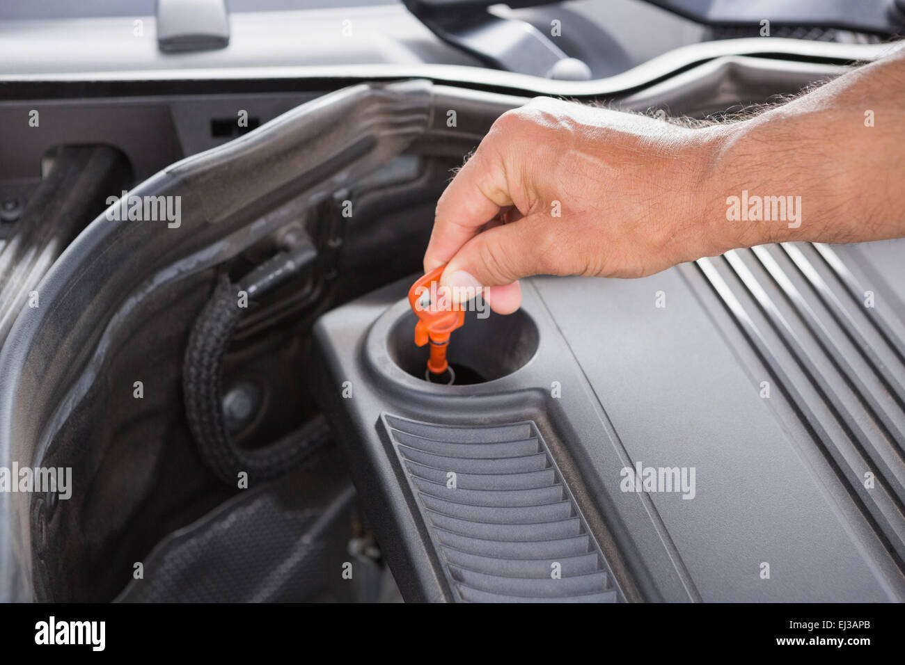 Man using dipstick to check oil Stock Photo Alamy