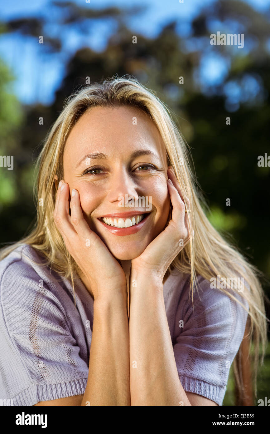 Pretty blonde smiling in the park Stock Photo - Alamy