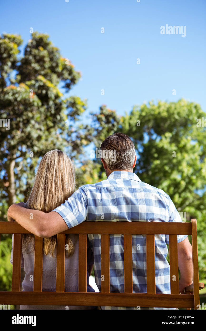 Couple relaxing in the park on bench Stock Photo - Alamy