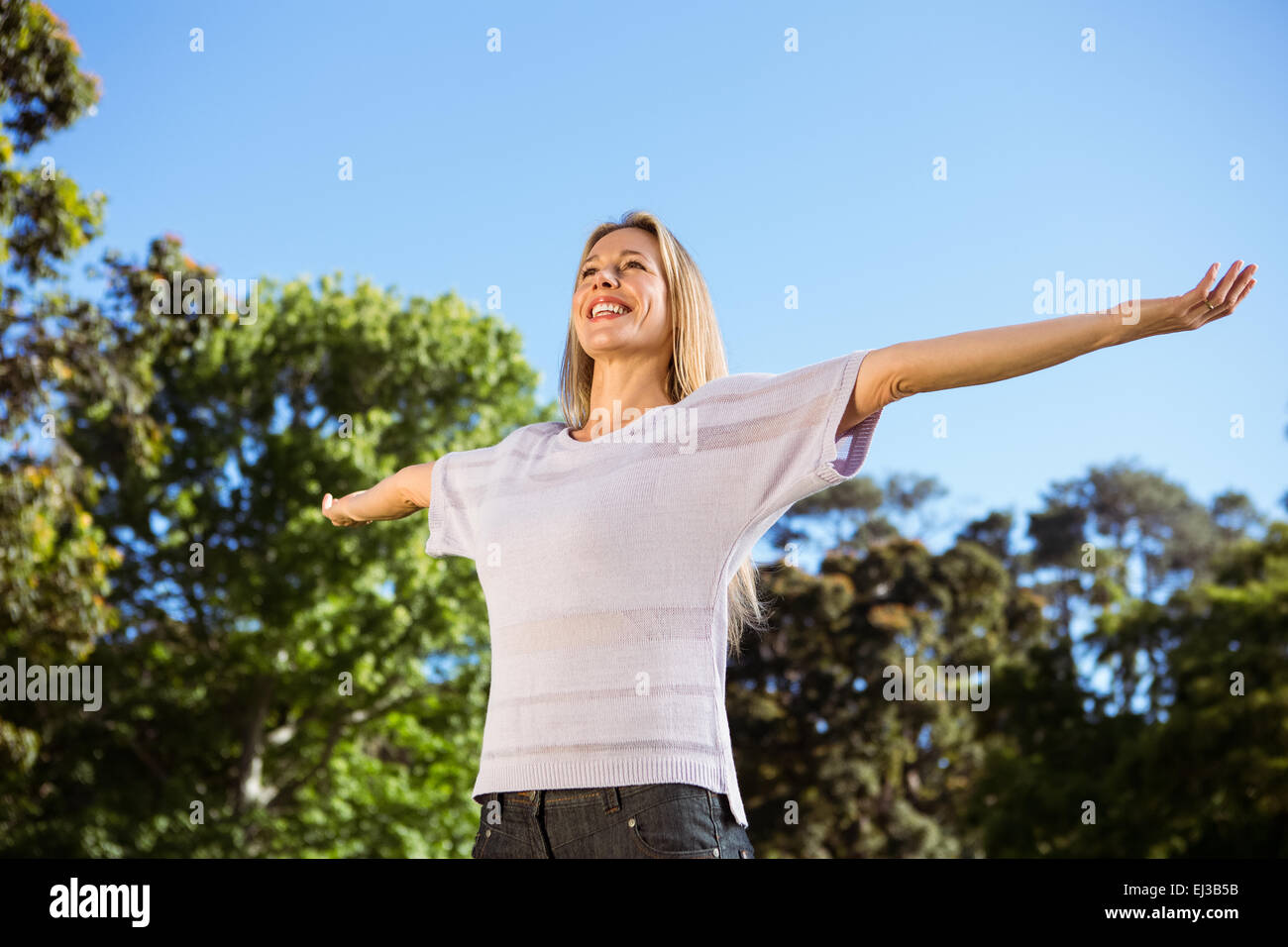 Pretty blonde smiling in the park Stock Photo - Alamy