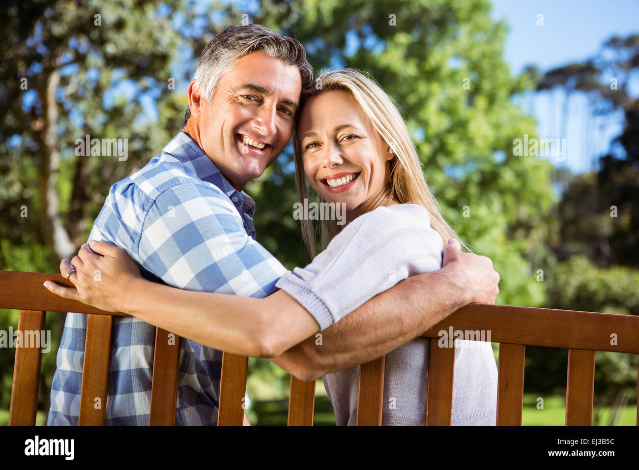 Couple relaxing in the park on bench Stock Photo - Alamy