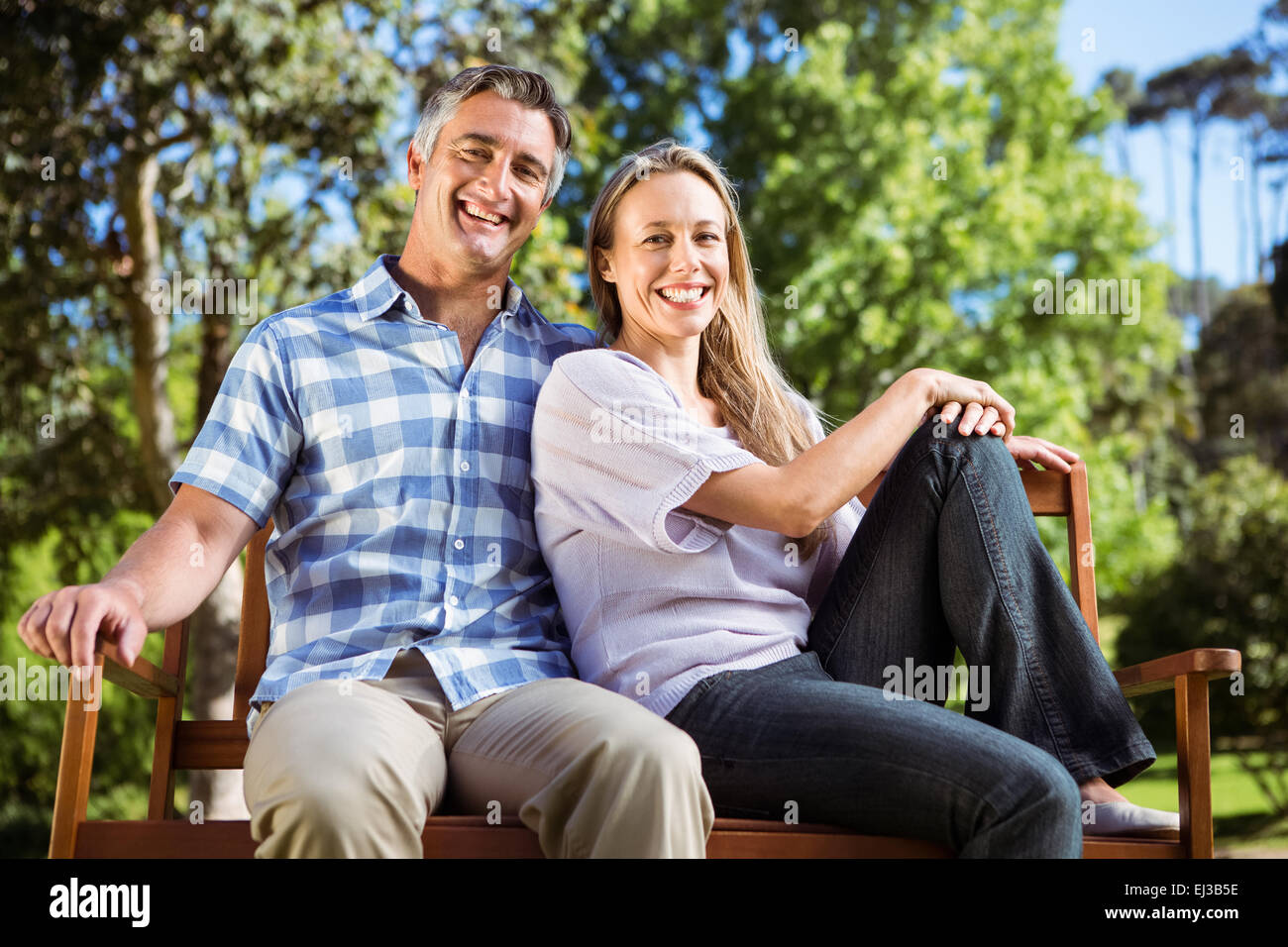 Couple relaxing in the park on bench Stock Photo - Alamy