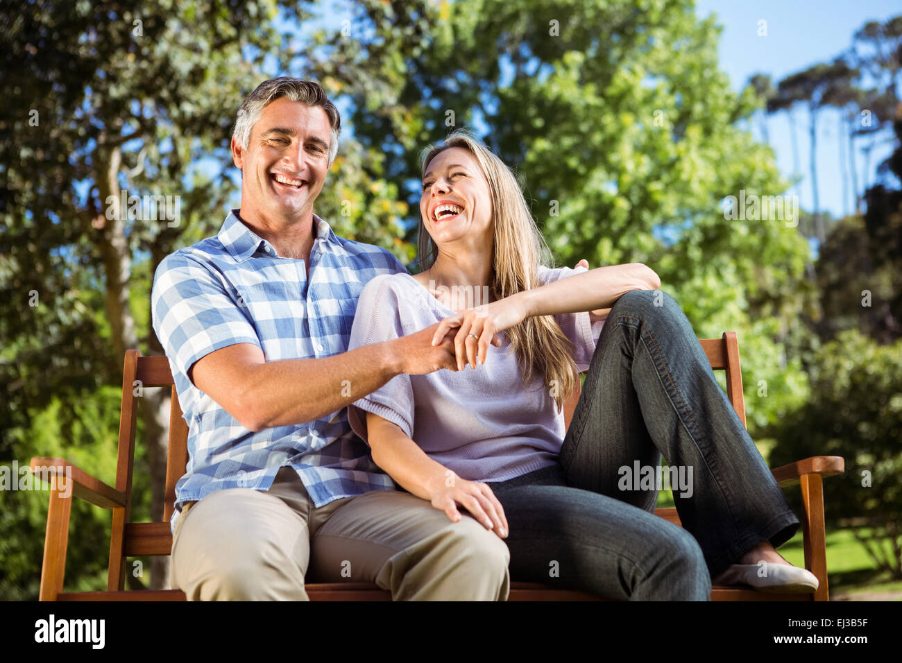 Couple relaxing in the park on bench Stock Photo - Alamy