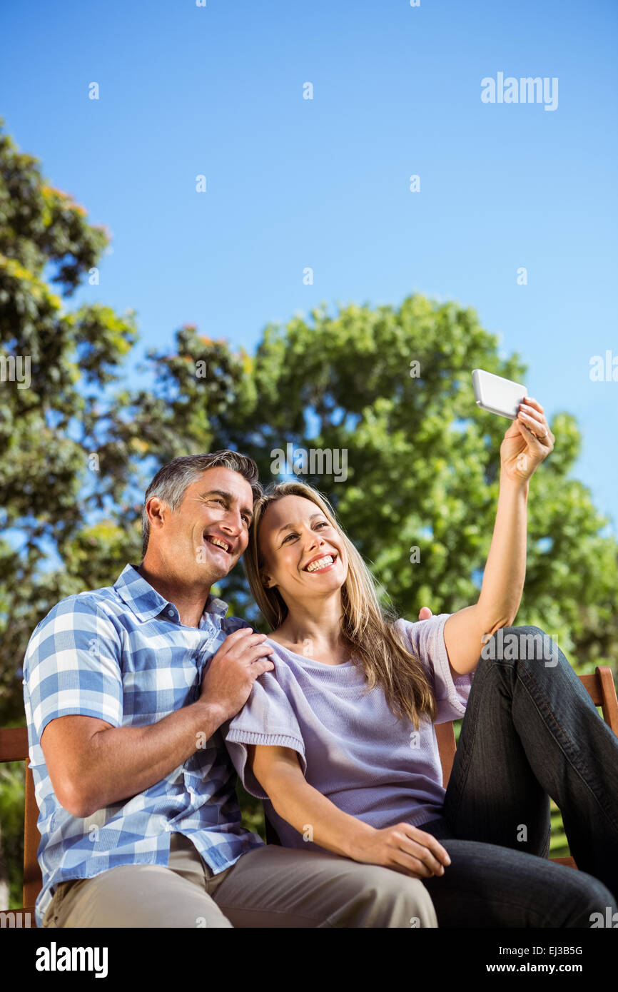 Couple relaxing in the park on bench Stock Photo - Alamy