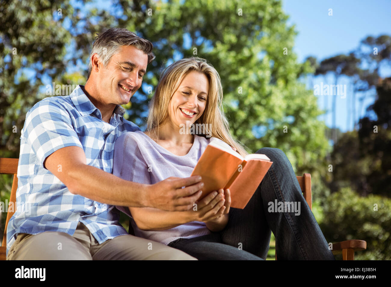 Couple relaxing in the park on bench Stock Photo - Alamy