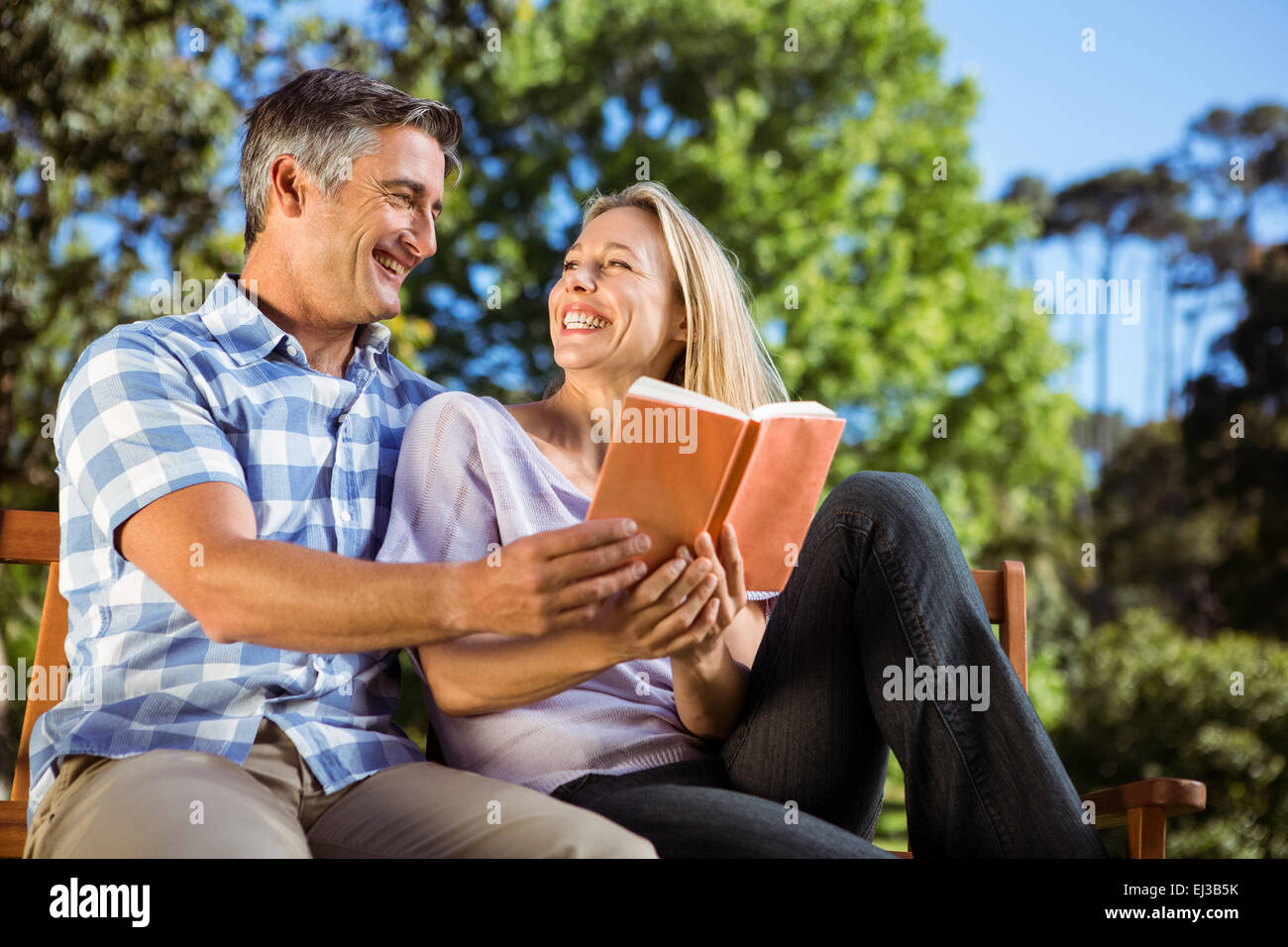 Couple relaxing in the park on bench Stock Photo - Alamy