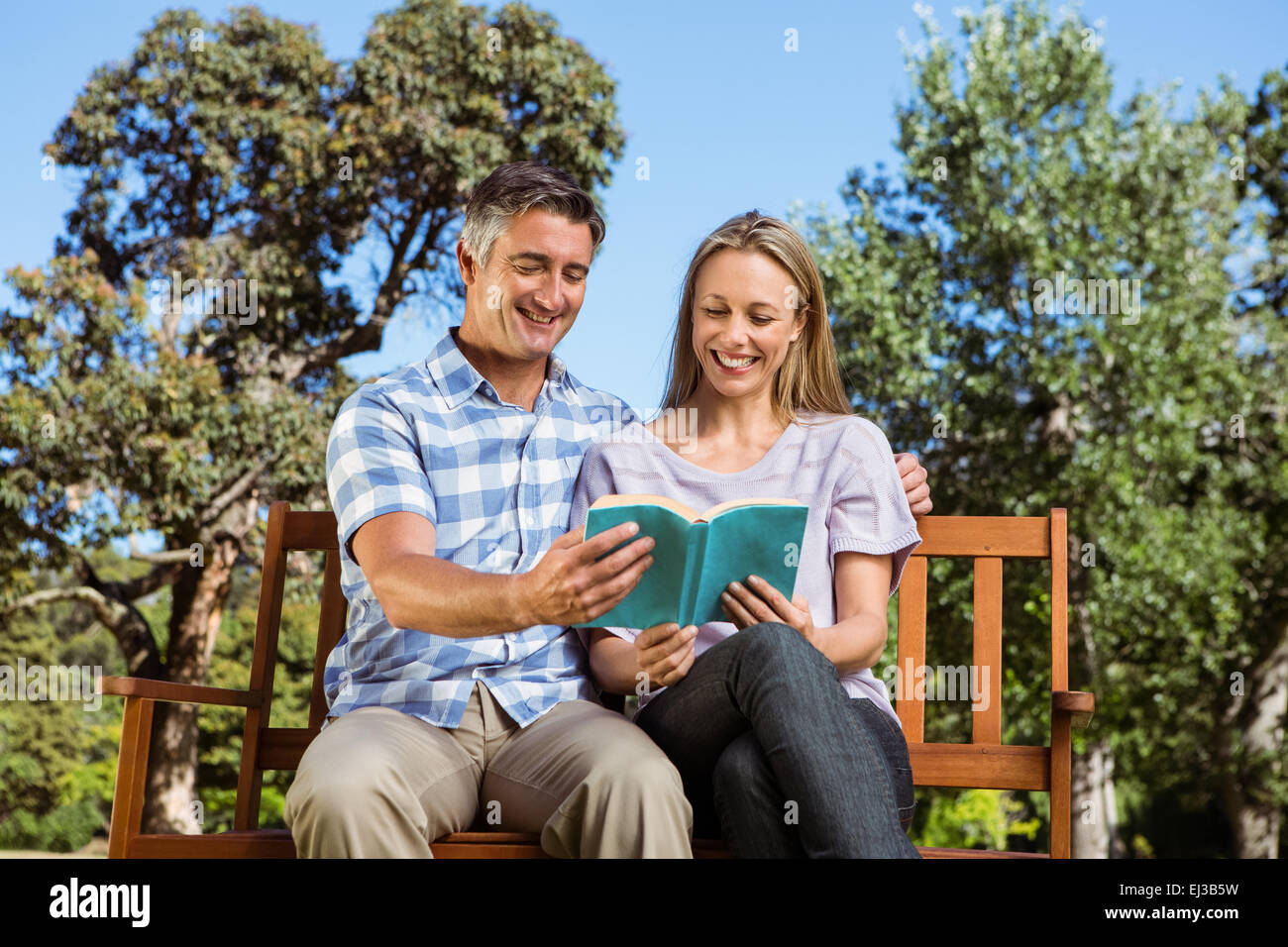 Couple relaxing in the park on bench Stock Photo - Alamy