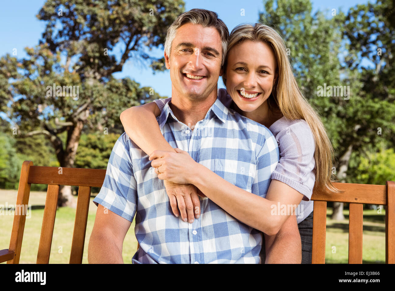 Couple relaxing in the park on bench Stock Photo - Alamy