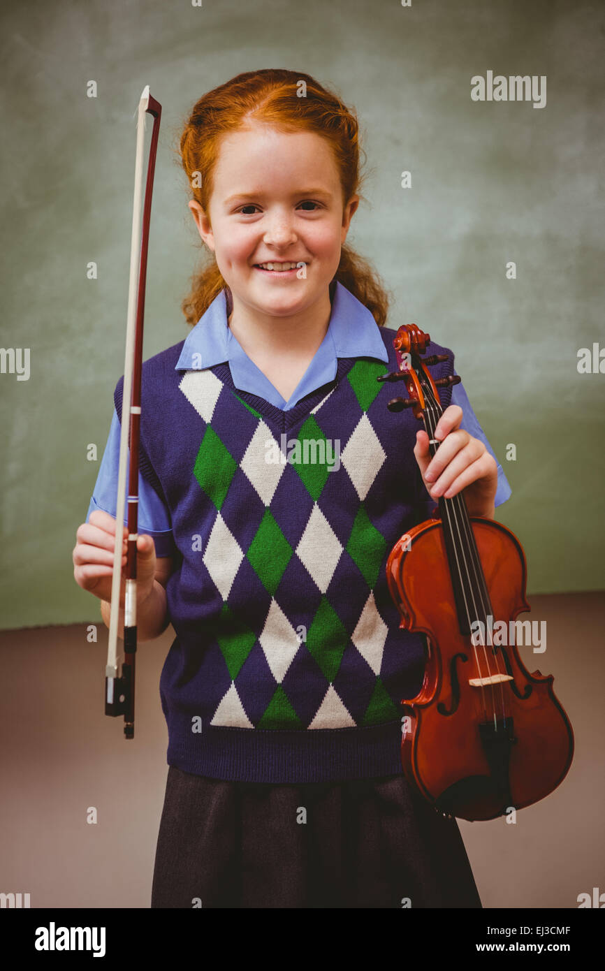 Cute little girl holding violin in classroom Stock Photo - Alamy