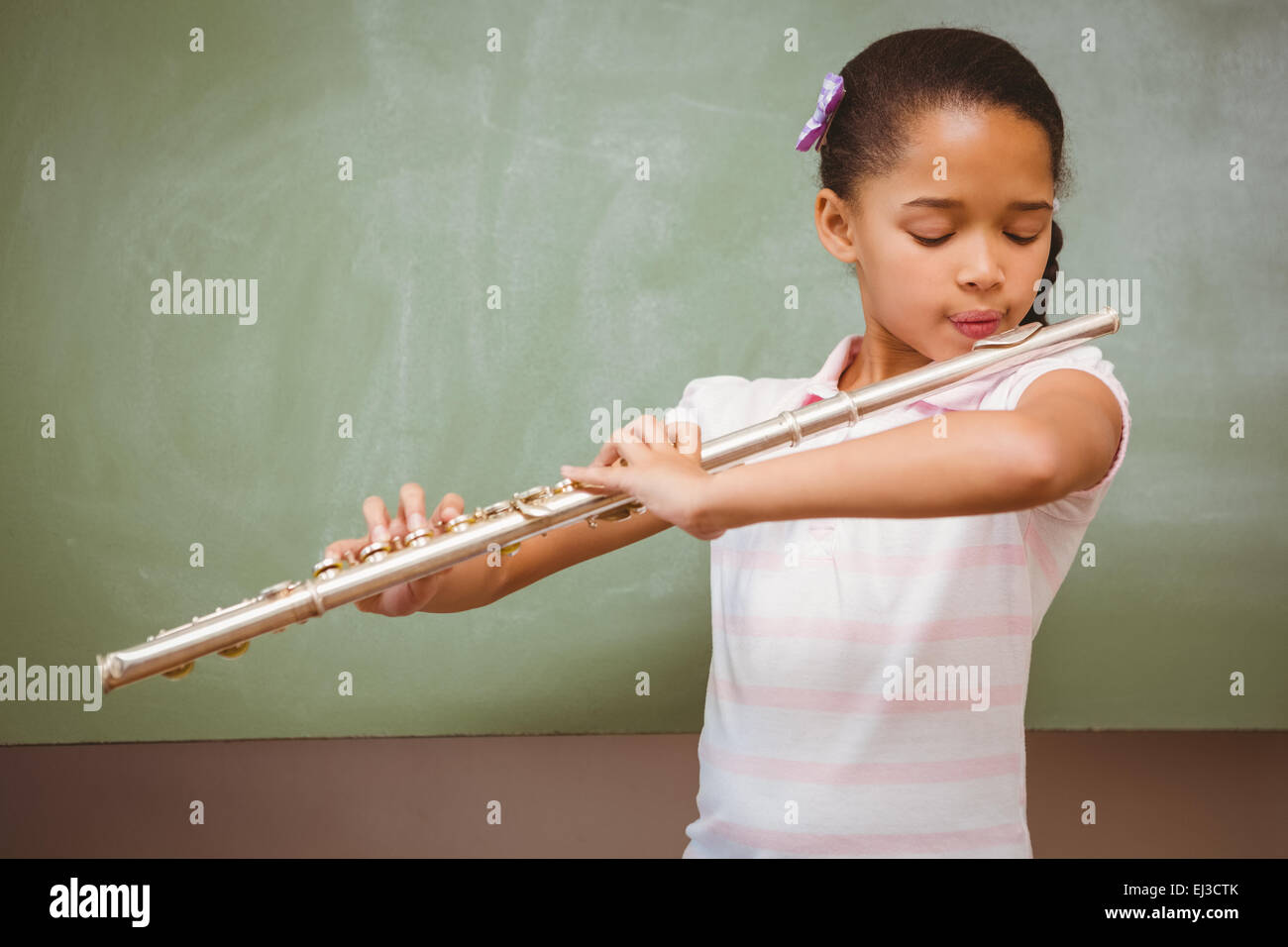 Little girl playing flute in classroom Stock Photo Alamy