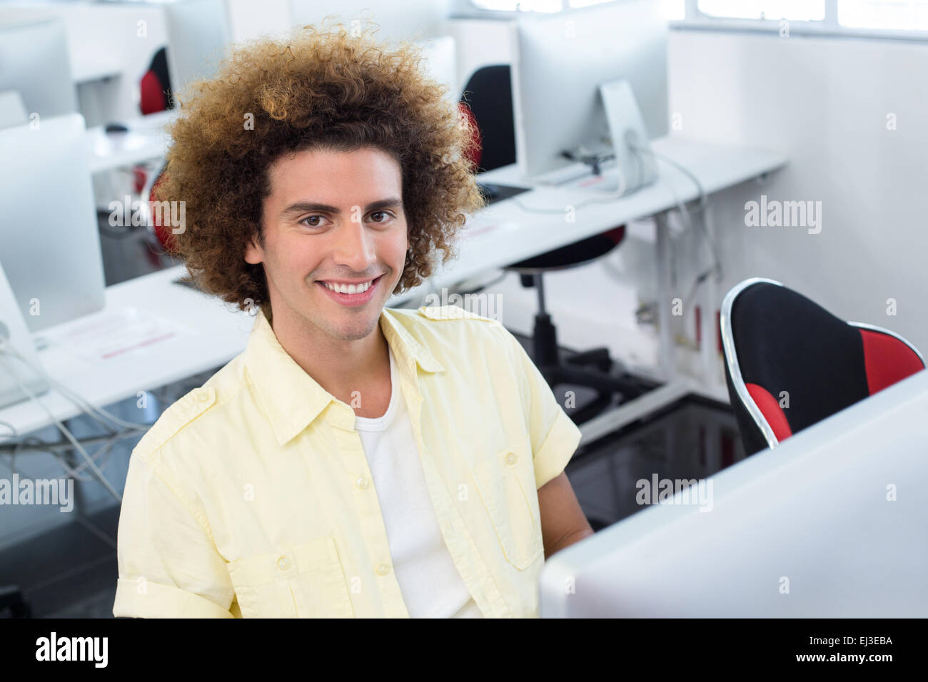 Smiling male student in computer class Stock Photo - Alamy