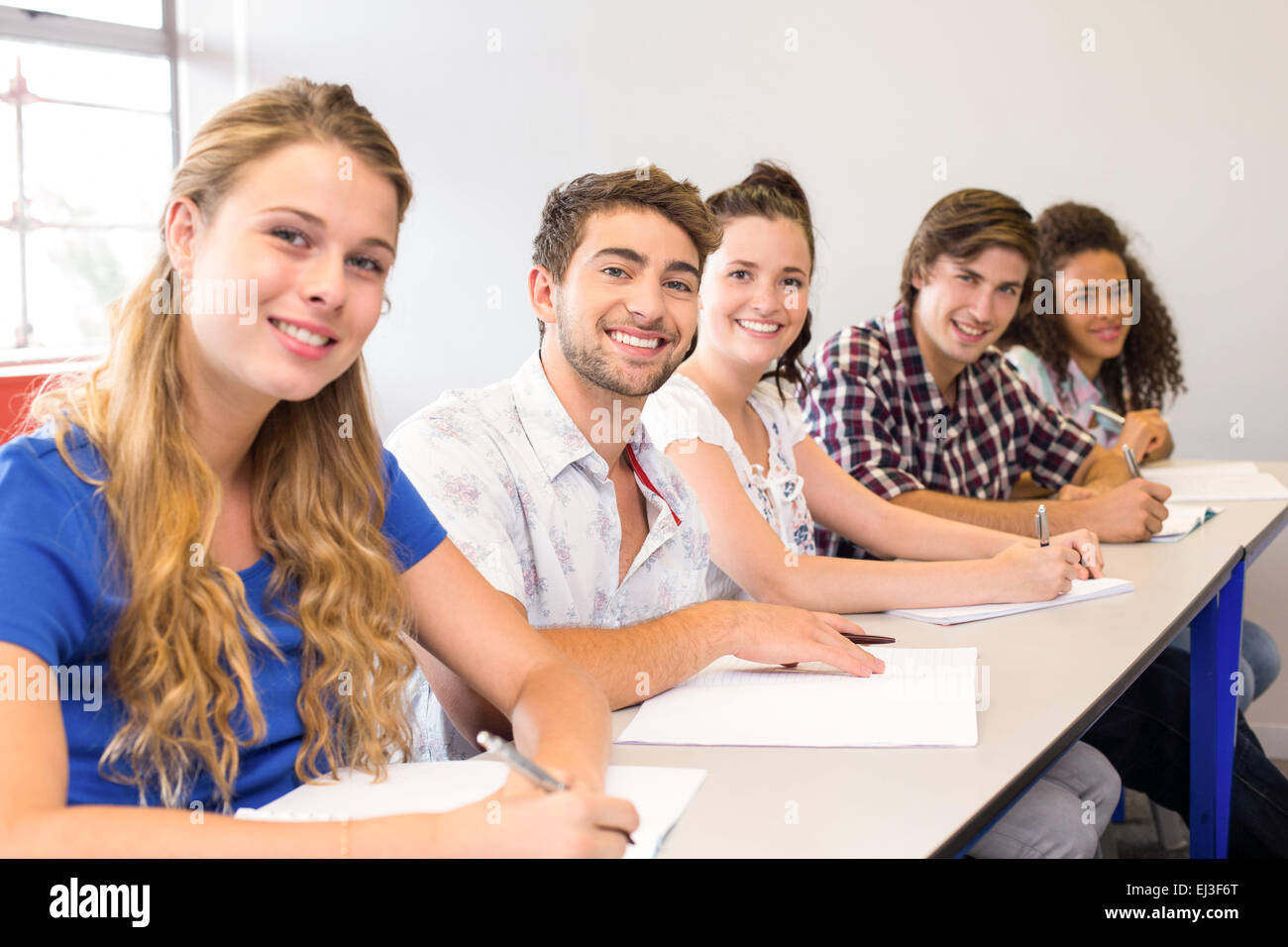 Students writing notes in classroom Stock Photo - Alamy