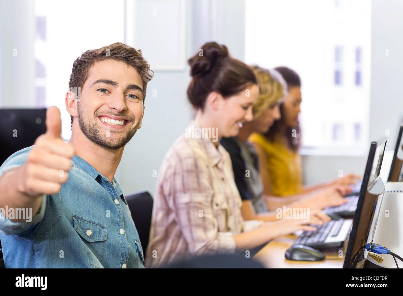 Student gesturing thumbs up in computer class Stock Photo - Alamy