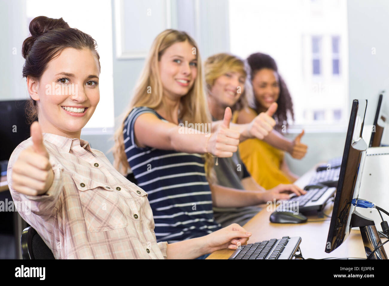 Students gesturing thumbs up in computer class Stock Photo - Alamy