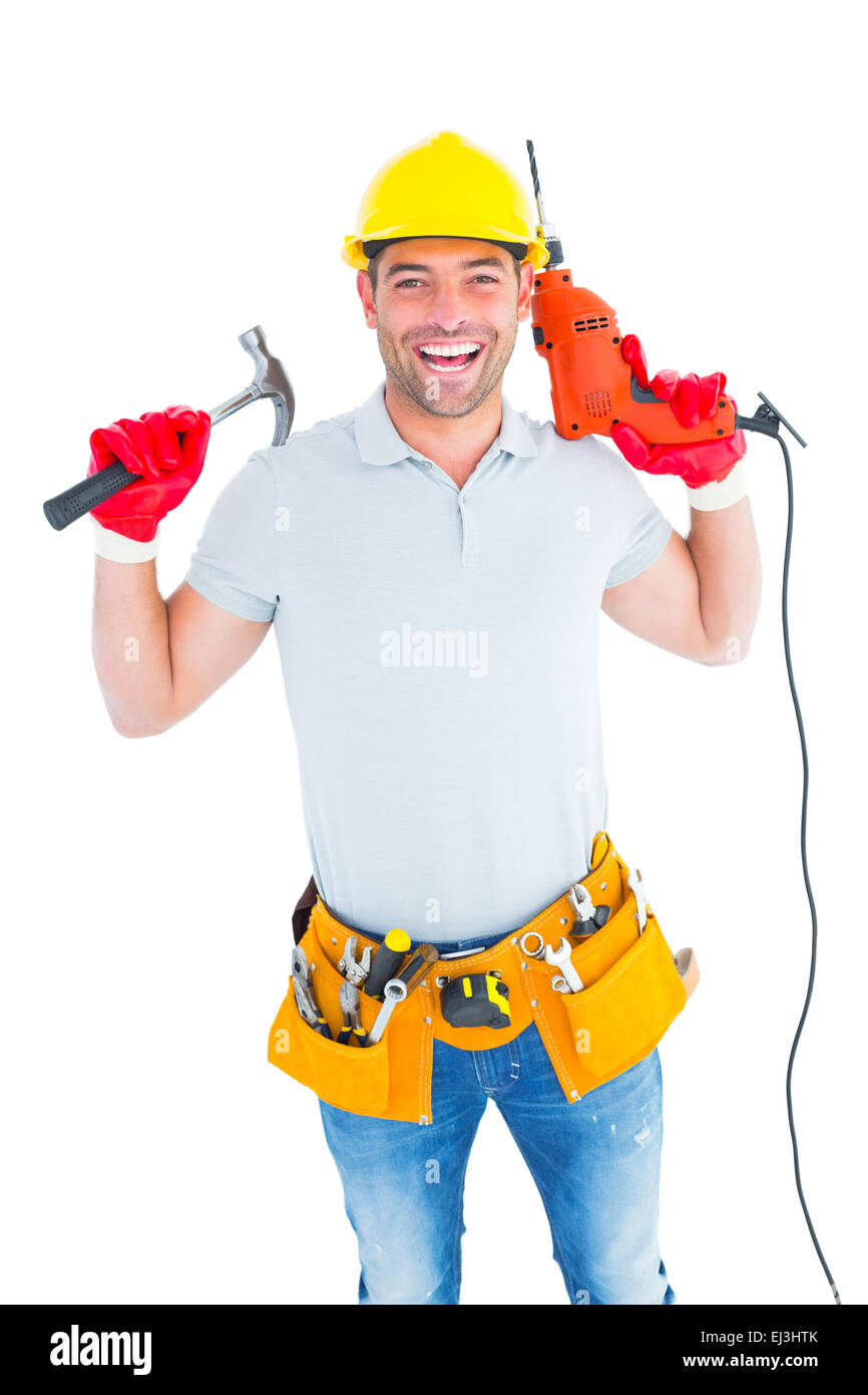 Smiling handyman holding hammer and drill machine Stock Photo Alamy