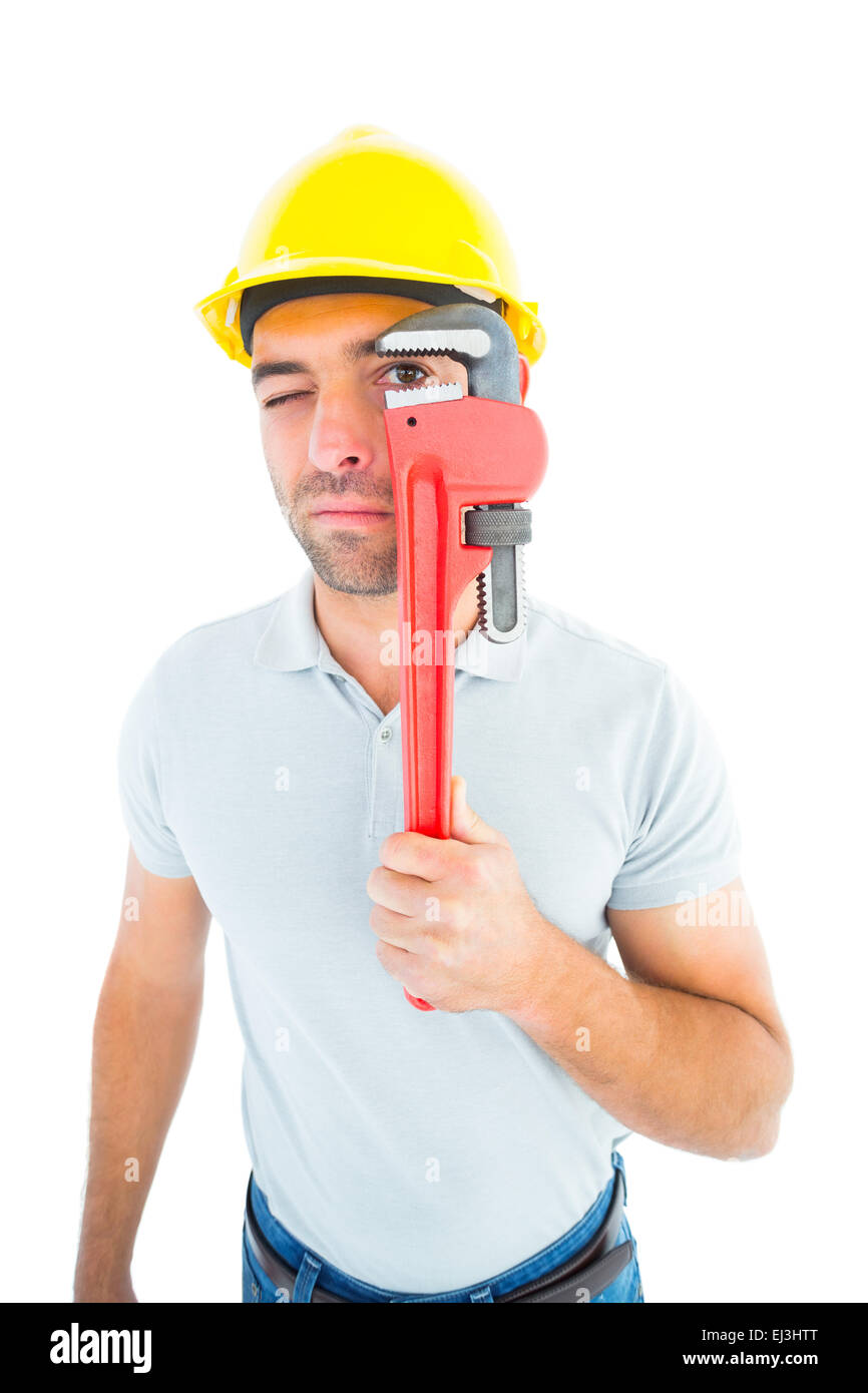 Manual worker looking through monkey wrench Stock Photo