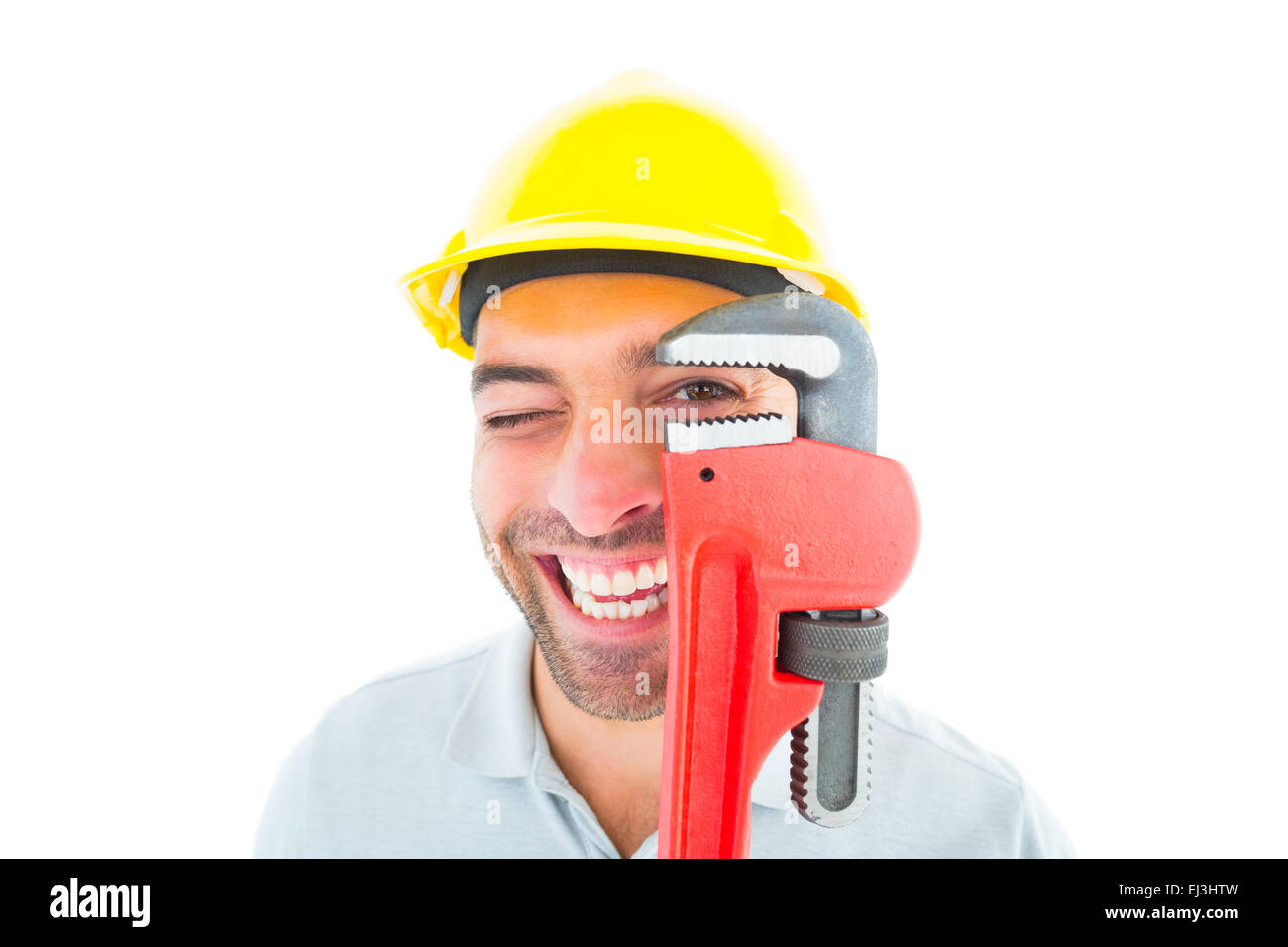 Cheerful handyman looking through monkey wrench Stock Photo