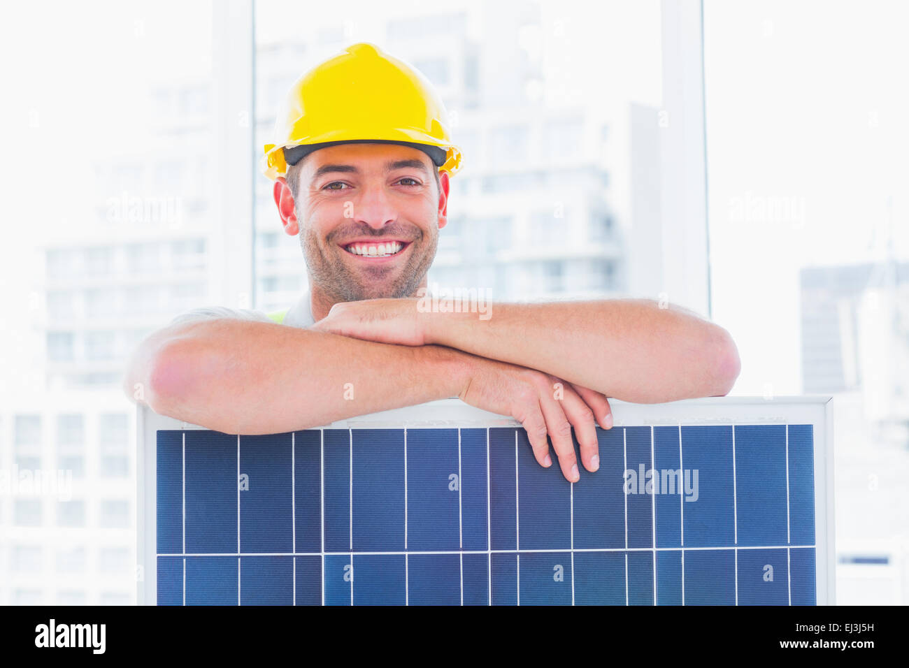 Smiling manual worker with solar panel in office Stock Photo Alamy