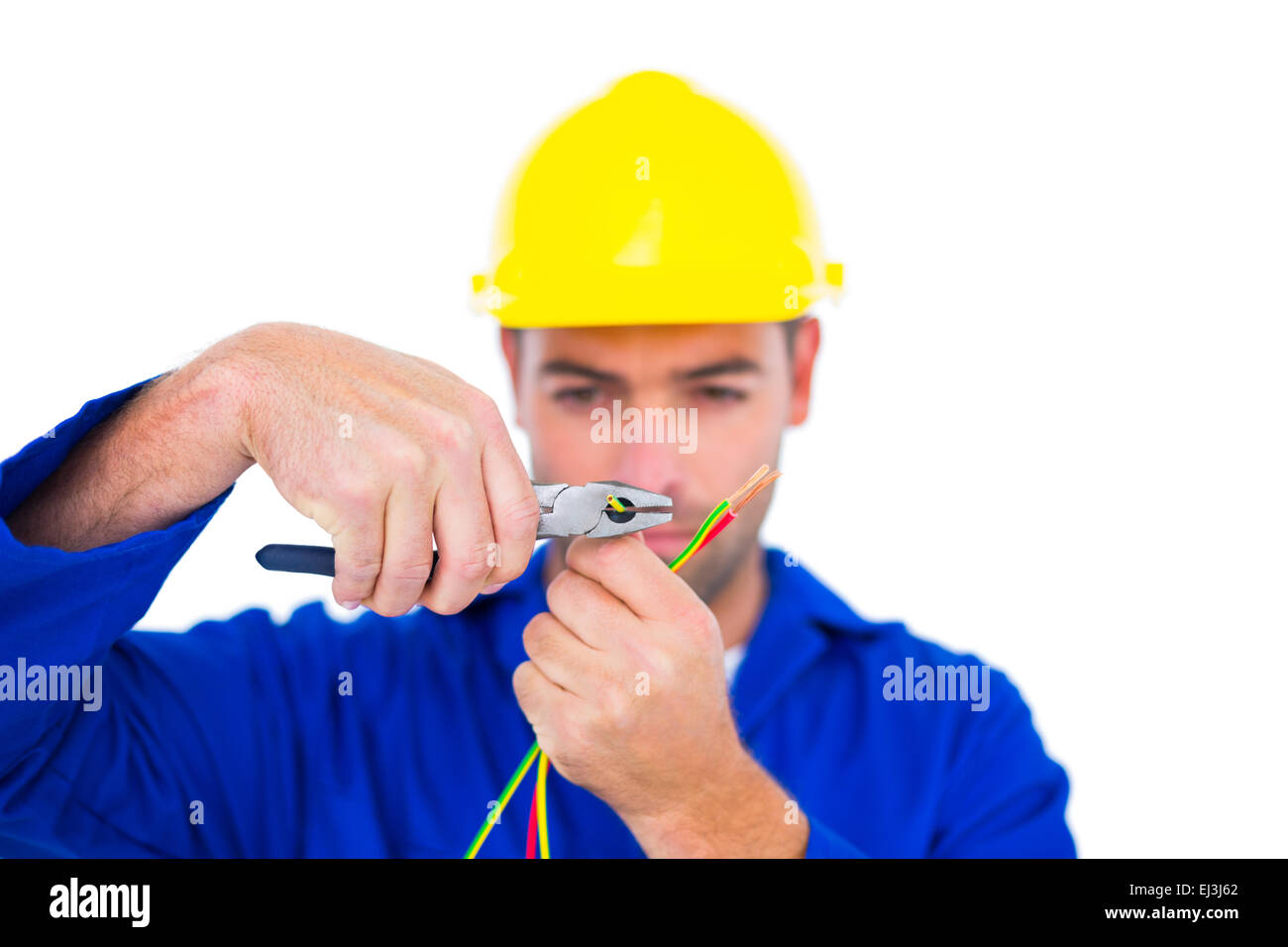 Electrician wearing hard hat while cutting wire with pliers Stock Photo