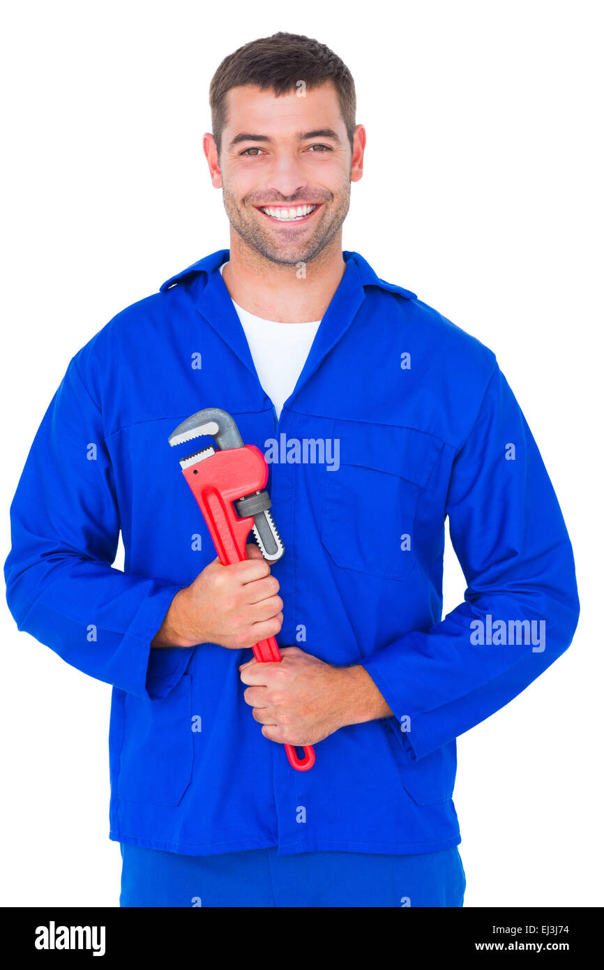 Smiling male mechanic holding monkey wrench Stock Photo