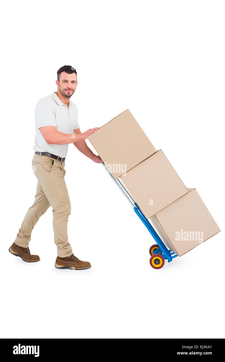 Delivery man pushing trolley of boxes Stock Photo - Alamy