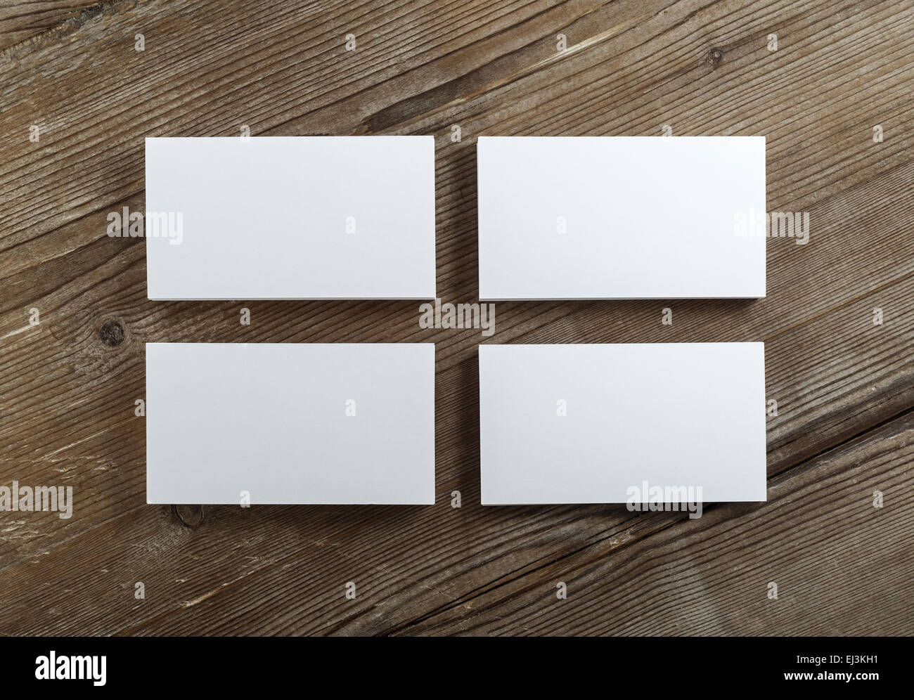Blank cardboard business cards on a dark wooden table. Template for ID