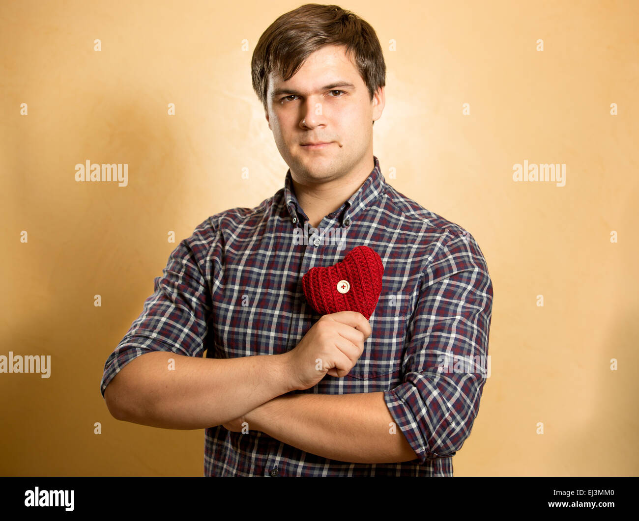 Portrait of elegant man holding red heart at chest Stock Photo - Alamy