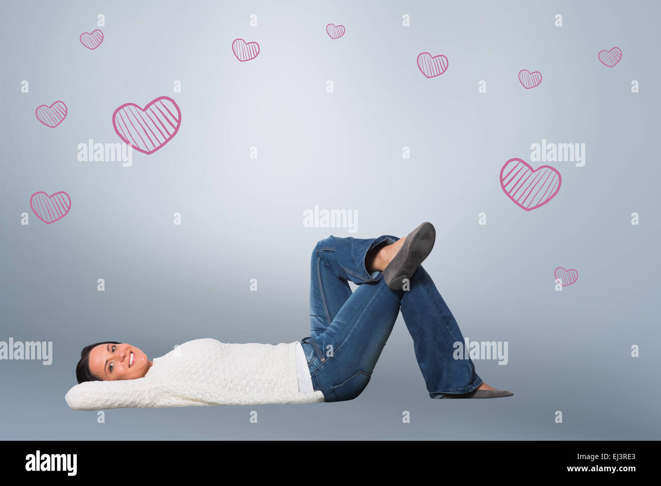Composite image of young woman lying on floor smiling Stock Photo