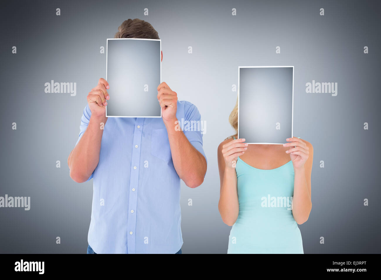 Composite image of young couple holding pages over their faces Stock Photo