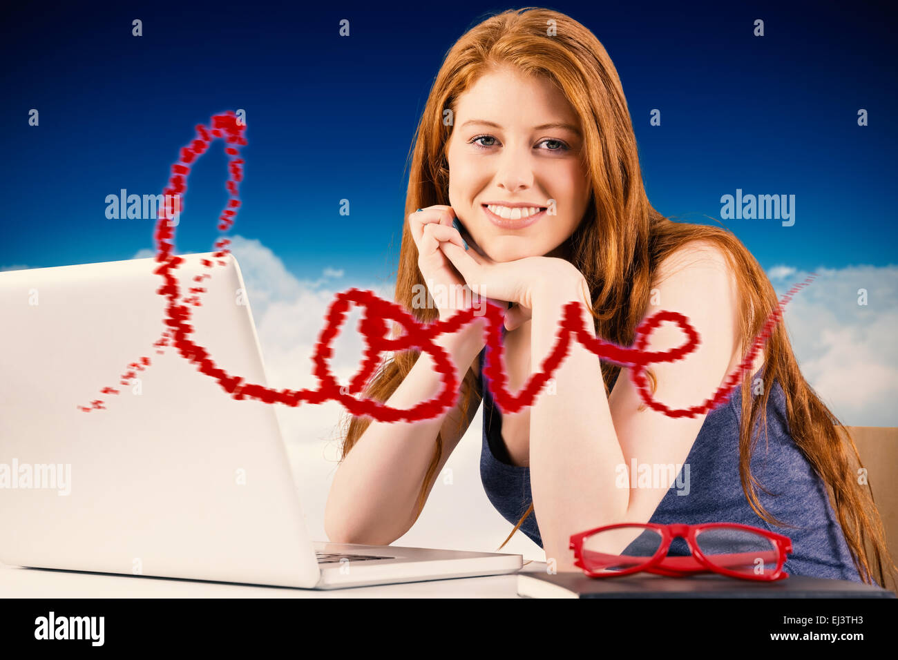 Composite image of pretty redhead working on laptop Stock Photo - Alamy